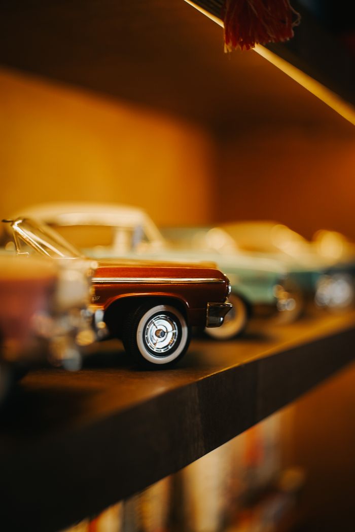 Charming close-up of vintage toy cars on a stylish shelf, evoking nostalgia and retro vibes.