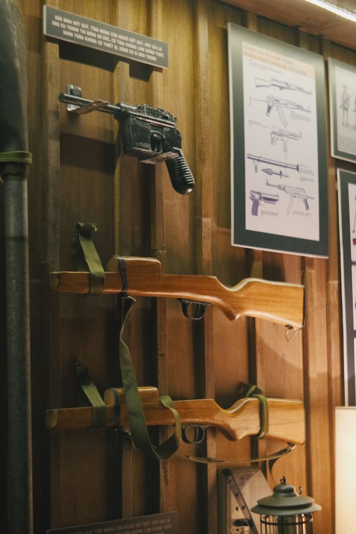 Display of historical firearms in a museum, showcasing weapon blueprints.