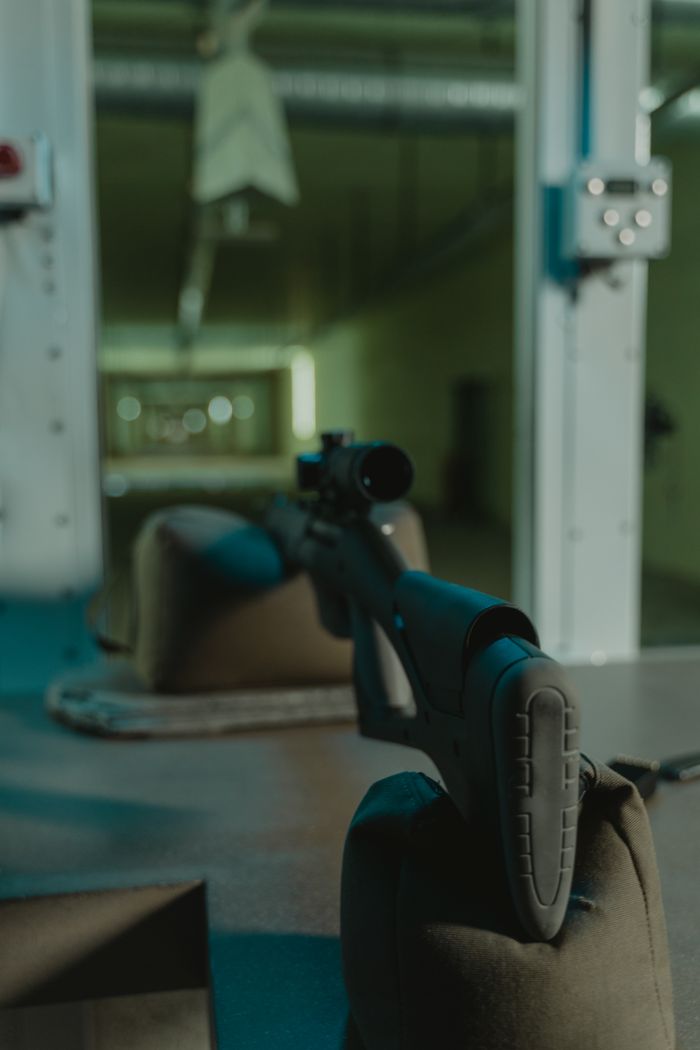 A sniper rifle setup for target practice in an indoor shooting range with a focus on accuracy.
